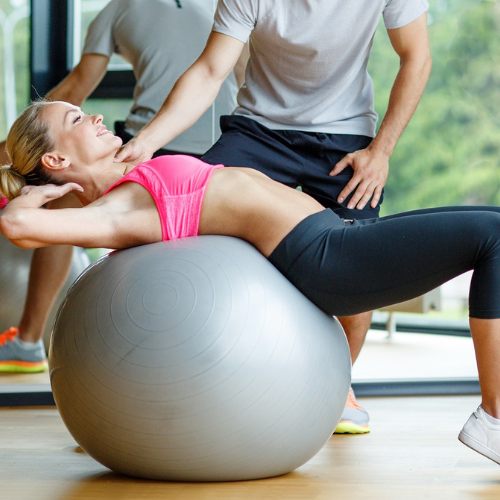 A lady having a personal training session with an exercise ball