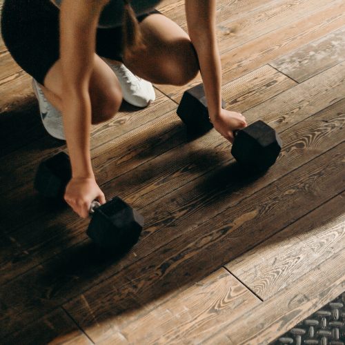 A lady having a personal training session with dumbbells